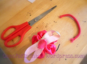 There those scissors are!  I cut the elastic off.  The flower was stitched together with the elastic & a felt back, so had to leave a that part of the elastic on it.
